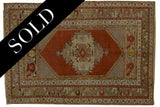 Vintage Oushak rug with rusty red central medallion and beige floral borders, 3'8