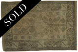 Vintage Oushak rug's lower right corner, charcoal geometric border on beige, with minor discoloration.