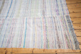 Visible sewn joint and soft, colorful stripe dashes on the vintage rag rug.