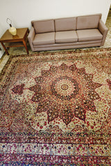 Antique Kerman rug, ivory field, red sun medallion, and intricate daisy motifs.