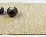 Handwoven cream cotton table runner, showcasing its distinct vertical texture and hemmed edge.