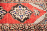 Classic medallion design and border of vintage red Turkish rug in blue and beige.