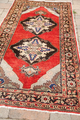 Close-up of the vintage red Turkish runner's classic floral border and gray corner.