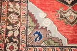 Close-up of vintage Turkish rug border, red field, stepped light blue corner with tribal motif.