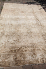 Detail of blanched vintage Oushak rug with subtle traditional patterns and aged texture.
