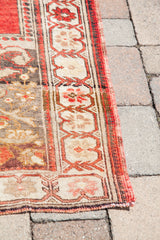 Vintage Oushak rug border and field detail in madder root red, beige, and charcoal.