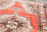 Textured madder red and charcoal bronze patterns on a Vintage Oushak rug, with fringe detail.