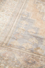 Faded Oushak rug texture with blanched ivory, silver, beige, and lavender hues.