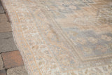 Corner detail of blanched vintage Oushak rug, with soft ivory, beige, and silver floral border.
