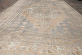 Blanched geometric border and faded field patterns in ivory, beige, and silver on vintage Oushak.
