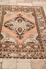 Bottom edge detail of vintage Oushak rug, showing peach field and curvilinear motifs.