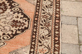 Vintage Oushak rug's decorative border with peach, beige, and dark brown geometric motifs.
