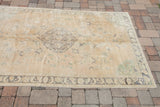 Pastel earth-tones and unusual mint-green corner spandrel on the vintage Oushak rug.