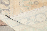 Vintage Oushak rug corner revealing mint-green spandrels, faded earth-tone pile, and woven foundation.