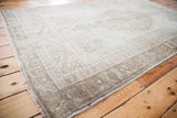 Blanched vintage Oushak rug's corner detail, highlighting subtle ivory and tan border patterns.