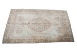 Blanched vintage Oushak rug with cream field and muted tan medallion pattern, 4'4