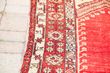 Intricate geometric border and rich rust field with subtle floral motifs of a vintage Turkish rug.