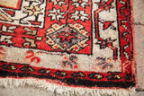 Hand-knotted fringe and deep rust geometric border detail of a vintage Turkish prayer rug.