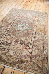 Vintage Anatolian rug's lower corner with soft fringe, lilac and brown geometric patterns.