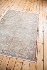 Detail of vintage Oushak rug fringe, light floral pattern, and geometric border.