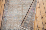Corner view of the vintage Oushak rug showing woven fringe and pastel floral motifs.