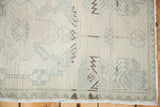 Vintage Oushak rug pile featuring blanched cream and soft sage geometric patterns.