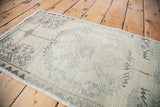 Blanched pile texture with subtle faded geometric patterns on a vintage Oushak rug.