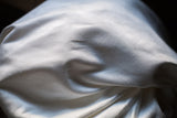 Soft texture and gentle folds of the bright white suede pillow backing.