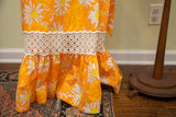 Lilly Pulitzer dress features white eyelet lace band and bright floral ruffled hem.
