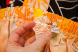 Hand holding authentic vintage 'The Lilly' and Saks Fifth Avenue tags.