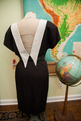 Back of vintage 80s black dress, dramatic white Peter Pan collar, deep V-neck.