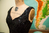 Vintage 80s black sequin dress shoulder, textured fabric with shimmering dark sequins.