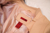 Vintage light pink leather jacket interior with shiny satin lining and garment labels.