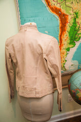 Back view of vintage light pink leather jacket, with tailored seams and zippered cuffs.
