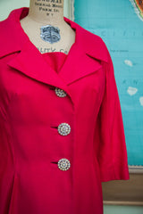 Close-up of the three large, sparkling rhinestone buttons on the vintage hot pink coat.