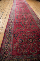 Angled view of the vintage Meshed runner's repeating raspberry red Sarouk floral sprays.