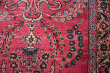 Intricate Sarouk floral sprays and detailed border on the raspberry red hand-knotted pile.