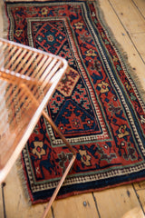 Antique Kurdish saddlebag runner at an angle, showcasing the geometric double medallions and intricate borders.