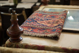 From a New England collection, this folded antique Kurdish rug shows its rich geometric design.