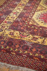 Close-up of the plush, hand-knotted pile and saffron yellow geometric borders of a vintage Daulatabad carpet.