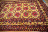 A perspective view of the vintage Daulatabad carpet's repeating red floral guls across a saffron yellow field.