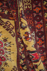 Thick hand-knotted texture of a vintage Daulatabad carpet in saffron and raspberry red.