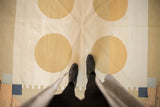 Handwoven contemporary kilim features abstract gold circles, ivory field, and navy rectilinear forms.