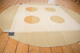 Modern abstract Kilim rug with round edge, rectilinear pattern, and dark denim square.