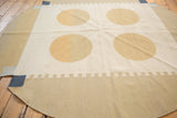 Abstract contemporary round Kilim rug detail, ivory field, dusty gold circles, rectilinear beige border.