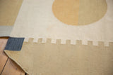 Contemporary Kilim rug corner with abstract rectilinear patterns in dark denim, sand, and ivory.