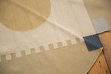 Corner of contemporary Kilim rug with rectilinear pale blue, gold, and denim blocks.