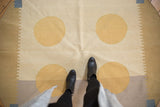 Abstract modern Kilim rug detail with dusty gold circles, ivory, and rectilinear pale blue corner.