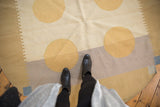 Contemporary abstract Kilim rug with dusty gold circles, ivory, sand, and pale mauve forms.