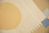 Abstract rectilinear and curved patterns in dusty gold, ivory, and pale blue kilim.